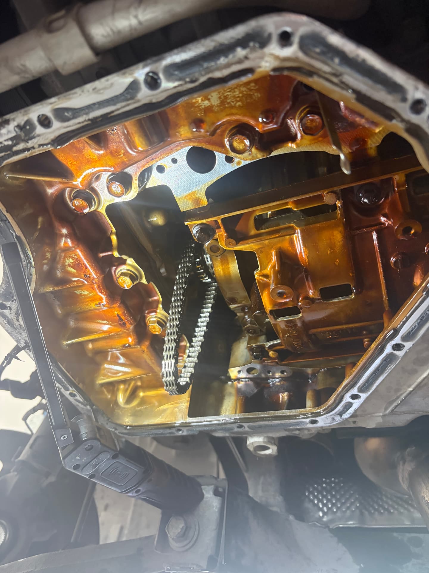 Timing chain exposed after oil pan removal at Johnny's Auto Repair in Victorville CA